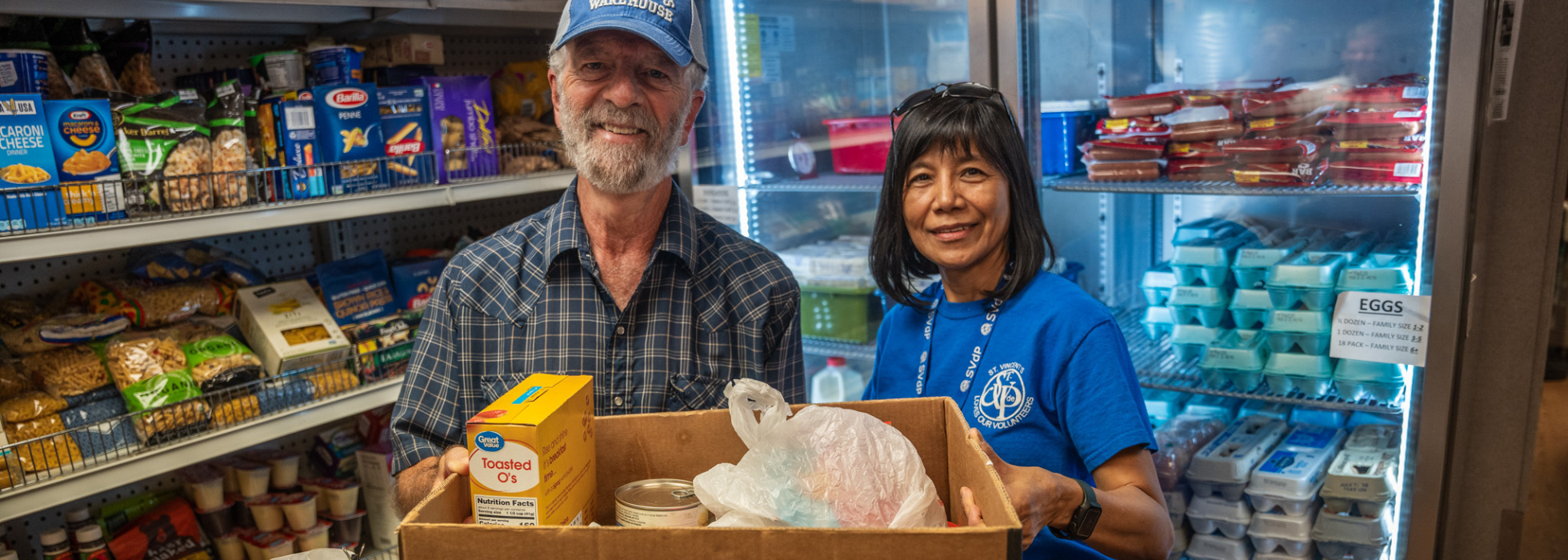 Man and woman holding a food box in a food pantry