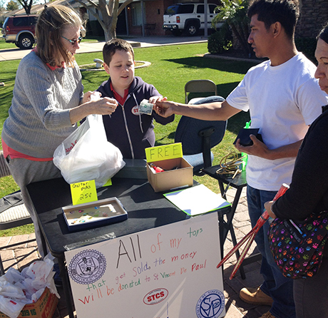 Adrien sells his toys at a garage sale to raise funds for SVdP.