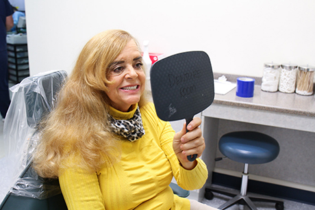 Ozanam Manor resident Karen sees her new dentures for the first time.