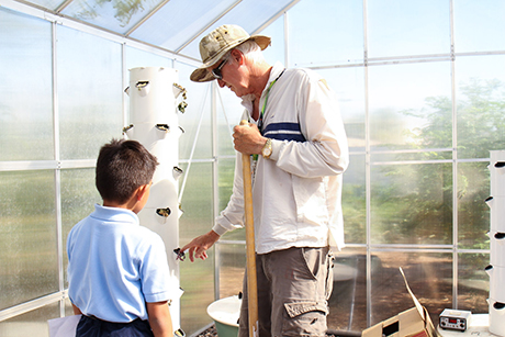 David Smith gives Sebastian from the Dream Center a tour of the farm.