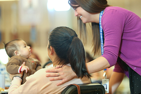 Danielle Ricketts, SVdP dining rooms manager, spends time with a mother and her child during the Family Evening Meal.