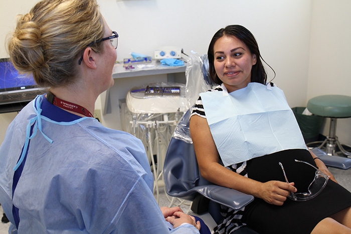 Dental clinic patient Nayeli speaks with an SVdP dental assistant.