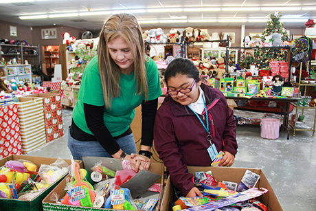 A volunteer helps a student shop for Christmas gifts