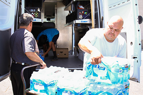 Joseph and Jose load the truck with bottled water.