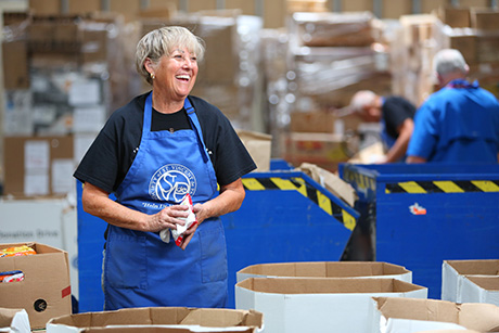 Volunteer sorts food in SVdP food warehouse.