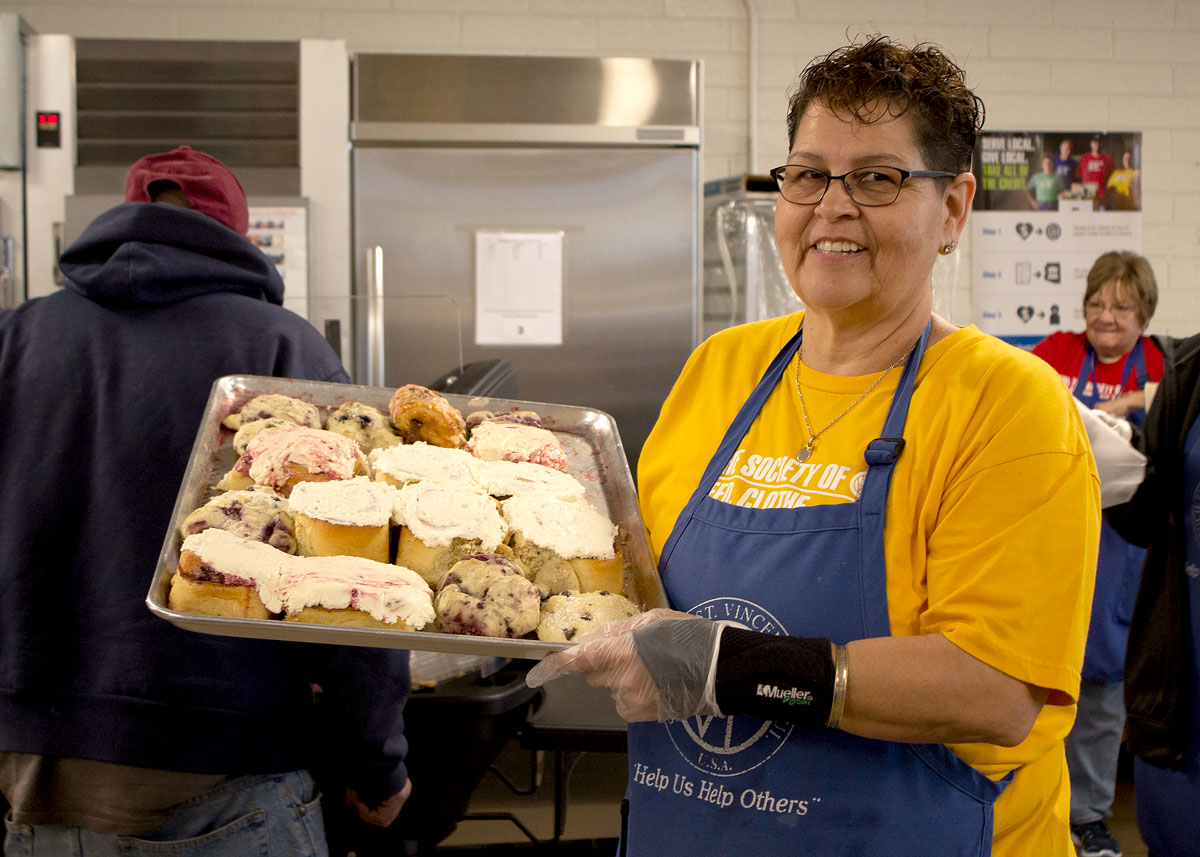 Mesa Dining Room Program Supervisor Carol Reed showcases a tray of Rise Up's donated baked goods.