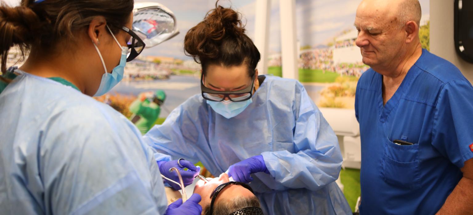 Three dentists working on a patient