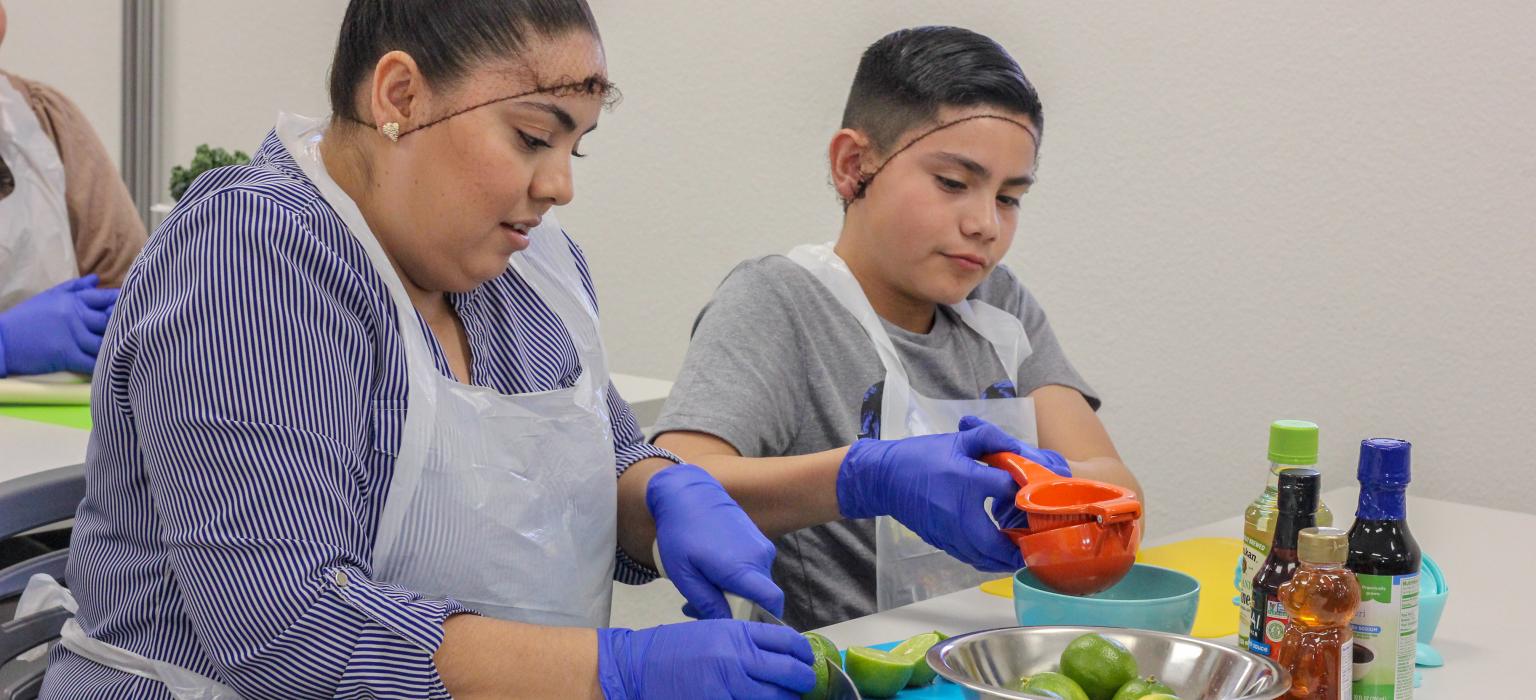 Family Wellness Center Header Mom and son squeezing limes for juice in a classroom