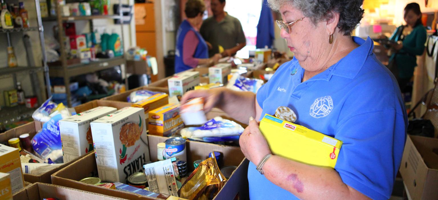 Woman putting cans of food into a box