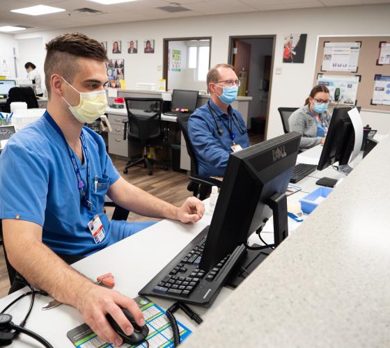 Man in scrubs working at a computer