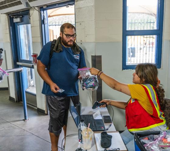 heat-relief-2025 volunteer handing a man a hygiene kit during daytime heat relief