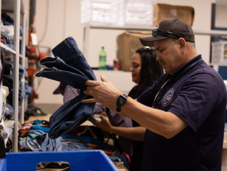 Man and woman folding jeans in St. Vincent de Paul resource center