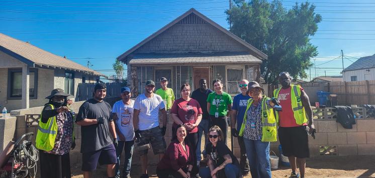 Members of the Neighborhood Brigade stand in front of the newly painted house.