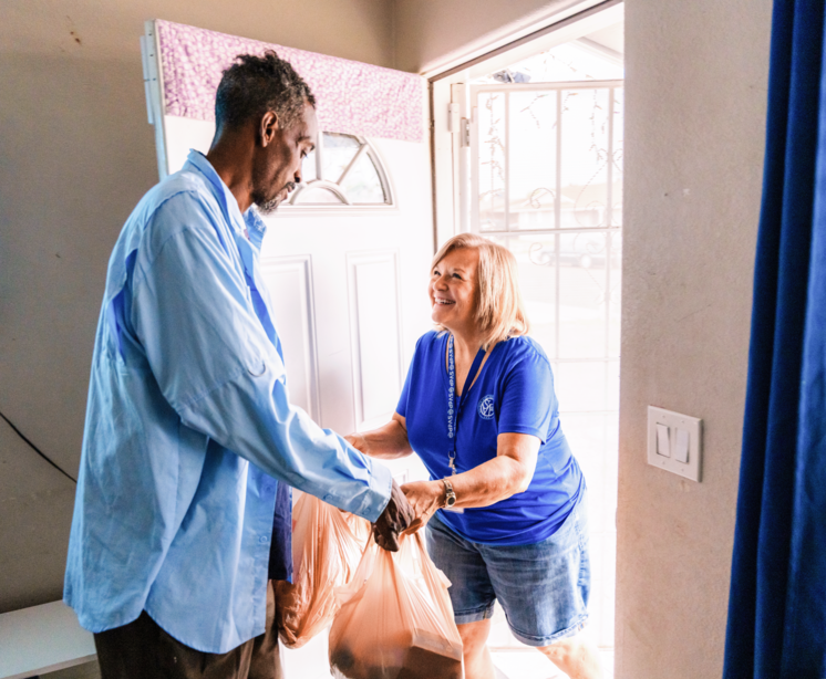Vincentian volunteer delivers food to a neighbor during a home visit.