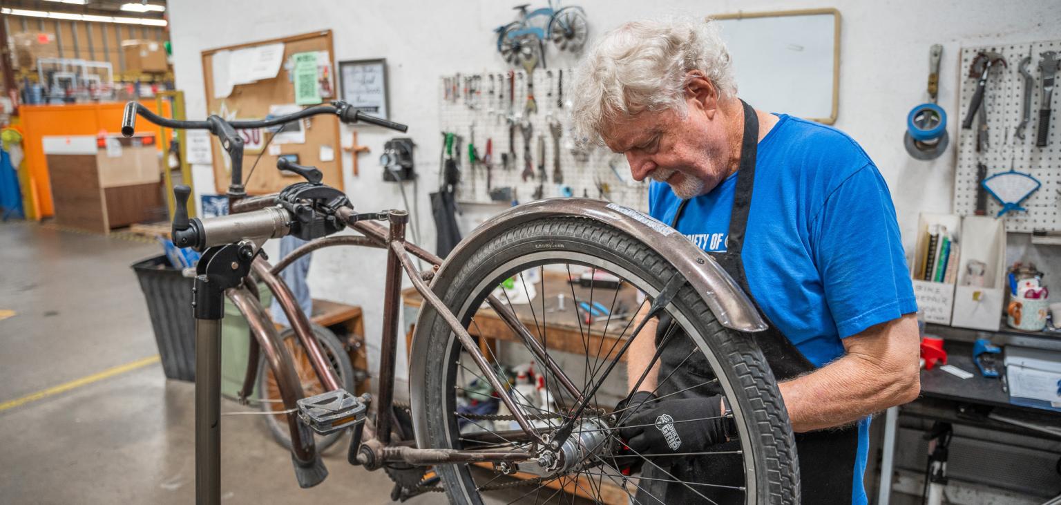 A volunteer in the SVdP bike shop fixes up a bike.