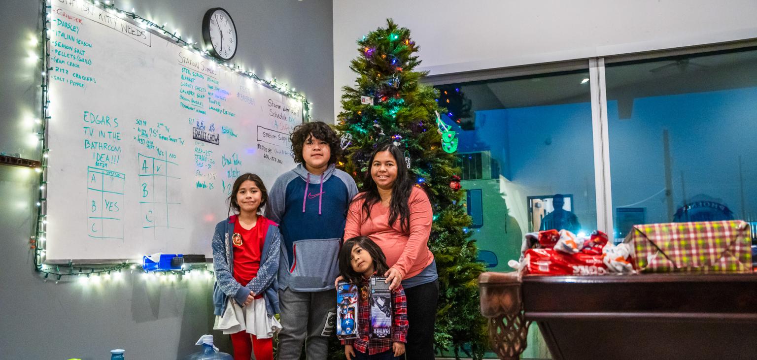 Nashelly poses with her kids in front of the Christmas tree in the Laveen Fire Station.