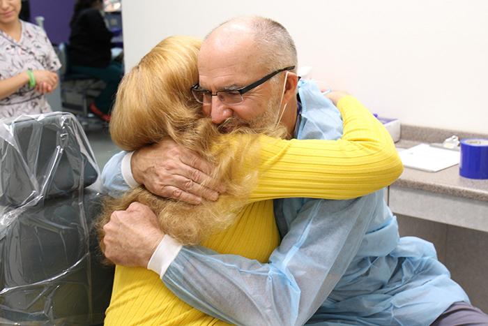 Oz Manor resident Cindy gives Dr. Rushlo a hug in SVdP's dental clinic.