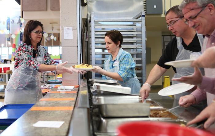 Volunteers serve food in a St. Vincent de Paul dining room.