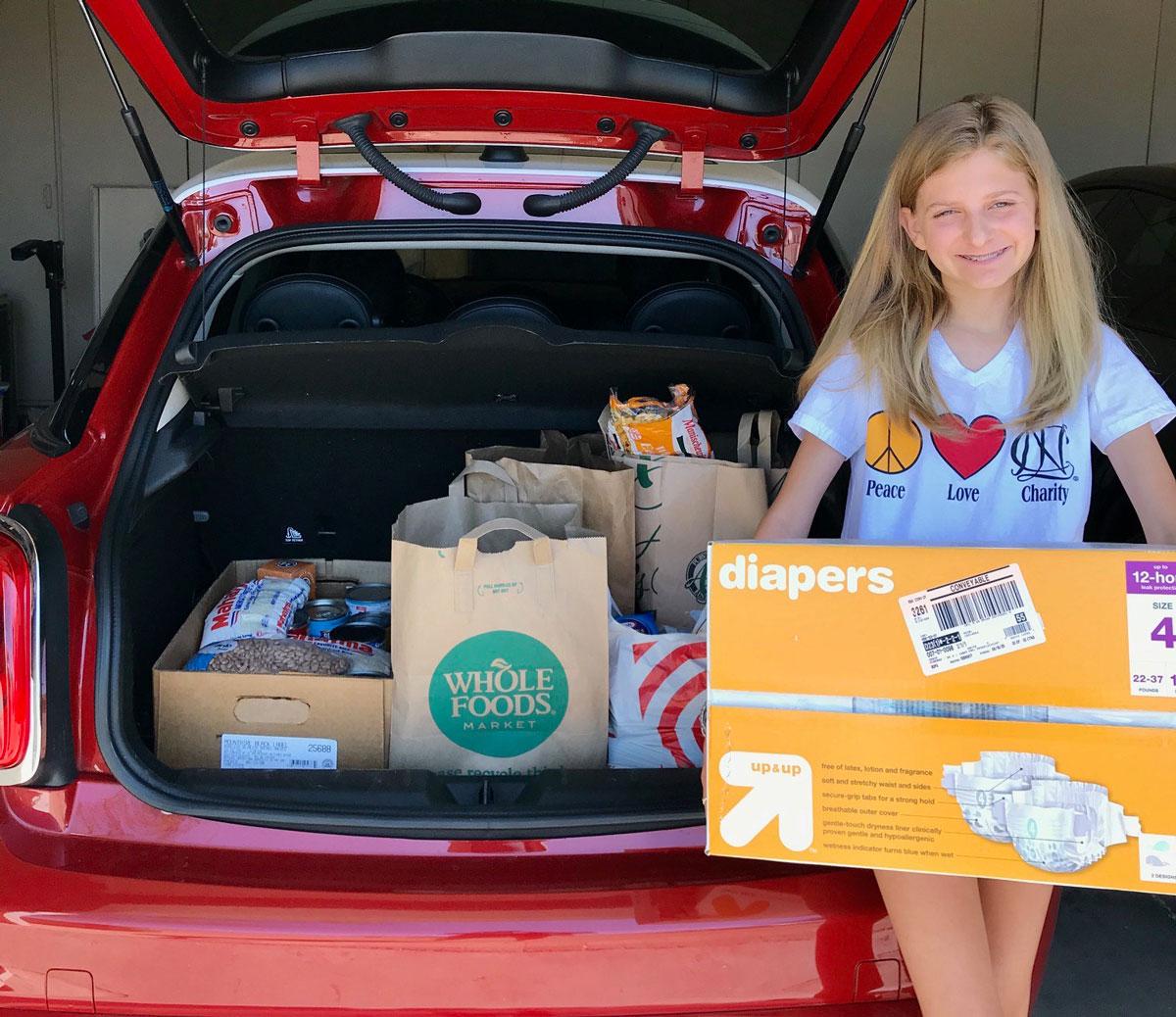 Lauren proudly displays the donations she and her mother Anne helped collect.