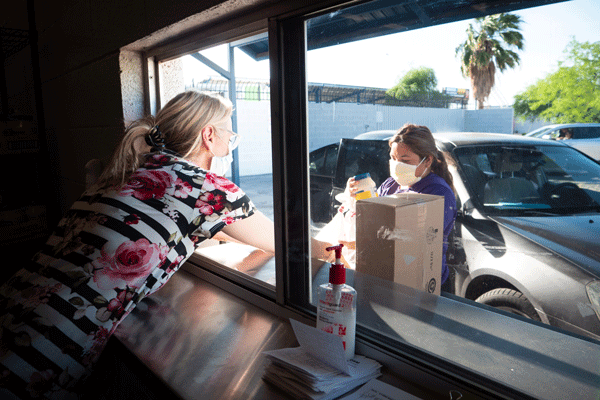 Family Dining Room Manager Cindy Bernardo offers to-go meals through a formerly defunct drive-thru window activated for pivoted COVID services.