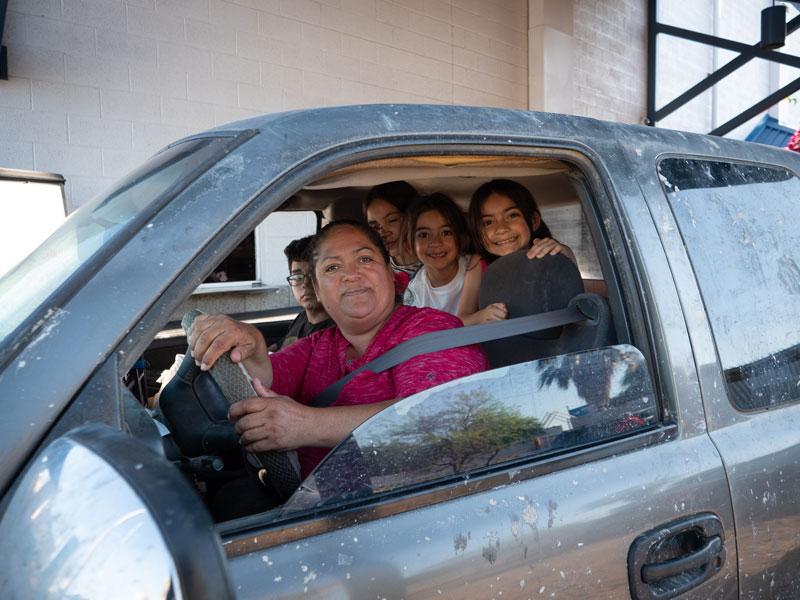 Rosa Guzman and the kids smile after going through the Family Dining Room drive-thru.