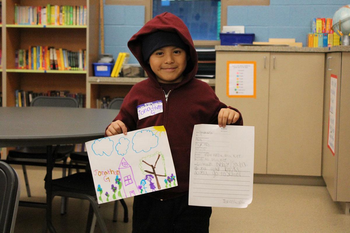 Dream Center student Jonathan, 8, holds up for display his letter and drawing to his Rwandan pen pal Dream Center student Jonathan, 8, holds up for display his letter and drawing to his Rwandan pen pal