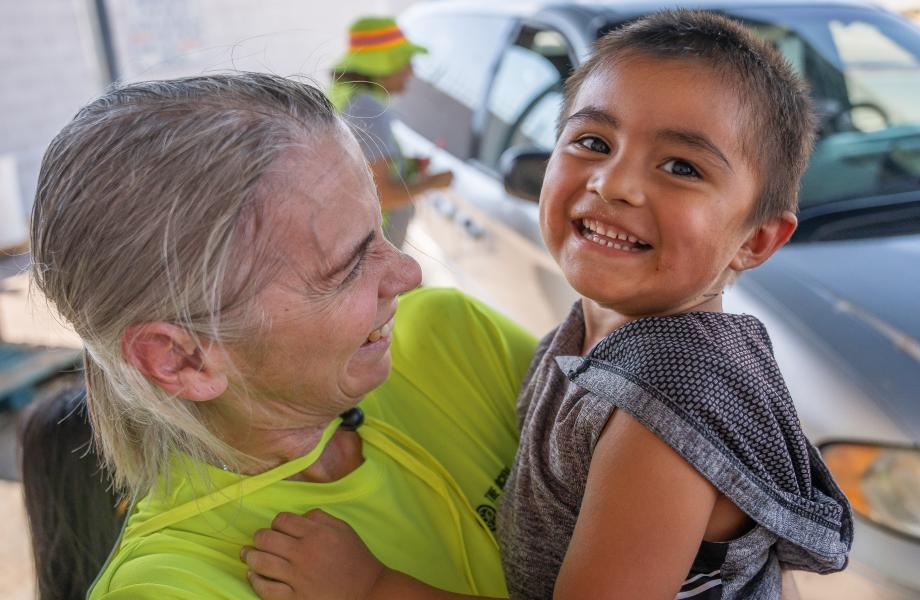 SVdP staff, Cindy Bernardo, holds a young guest.