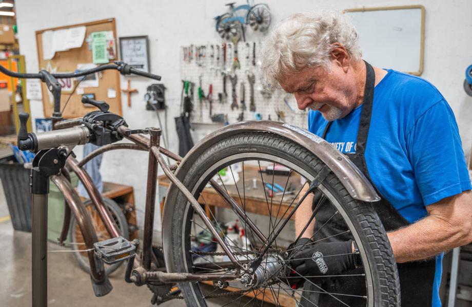 A volunteer in the SVdP bike shop fixes up a bike.
