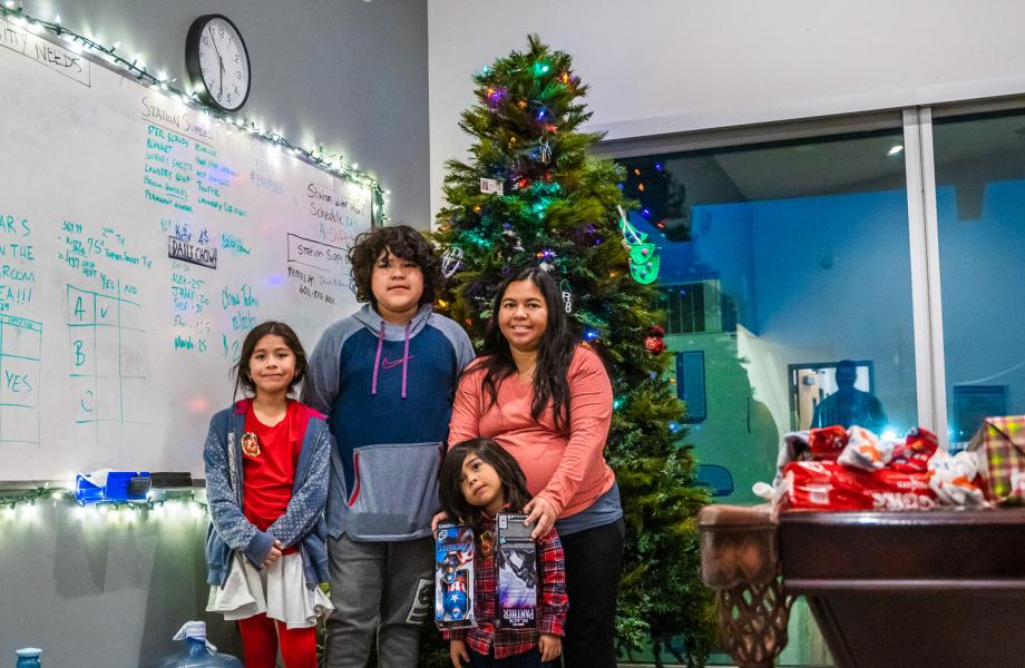 Nashelly poses with her kids in front of the Christmas tree in the Laveen Fire Station.