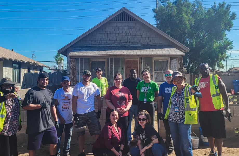 Members of the Neighborhood Brigade stand in front of the newly painted house.
