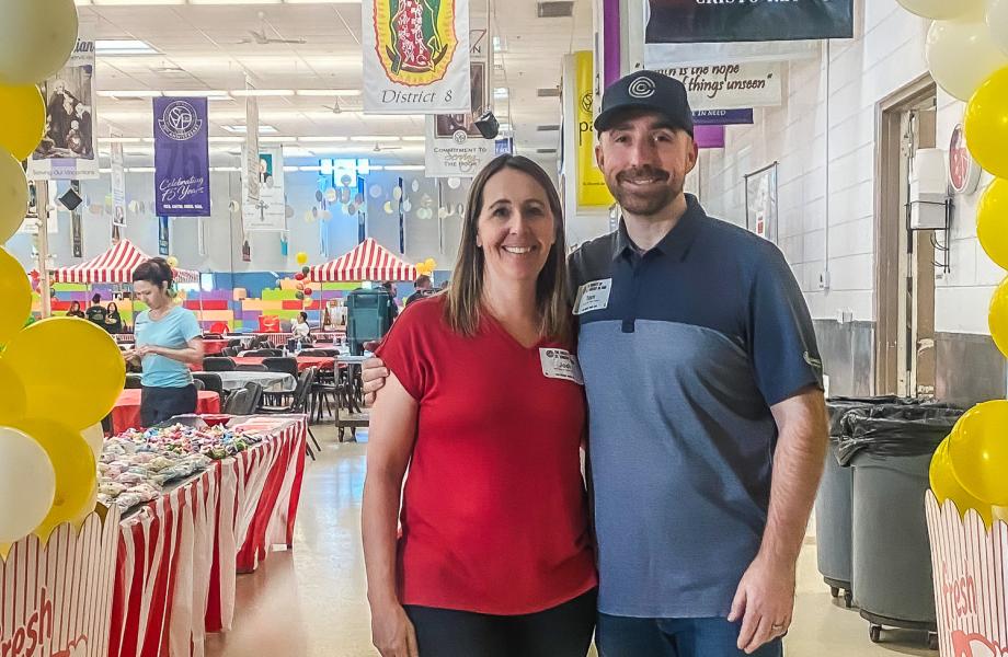 Tom and Jodi Chermack stand at the carnival they organized and sponsored at SVdP's Hall of Banners.