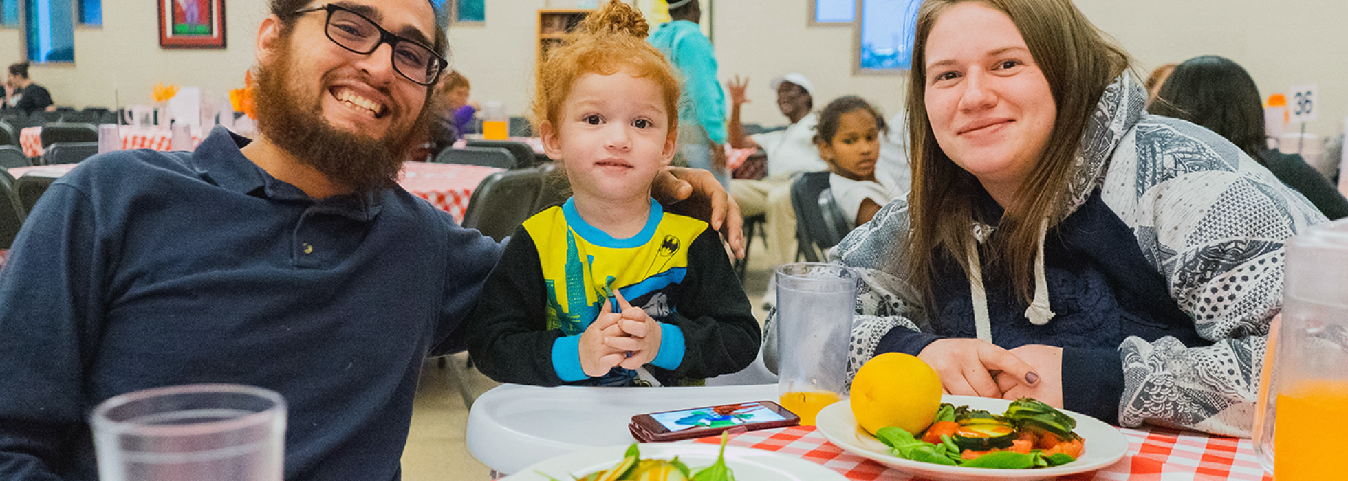 family-food-campaign-header Family sitting at a table eating food