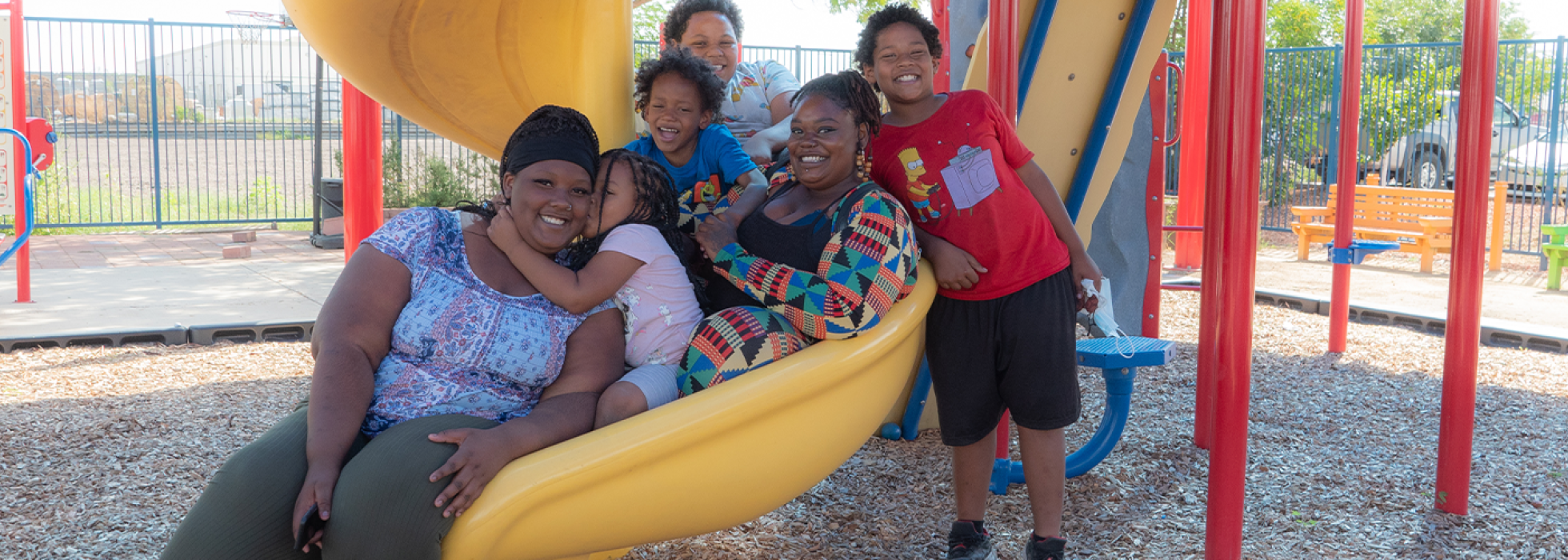 Family sitting in a slide together on a playground