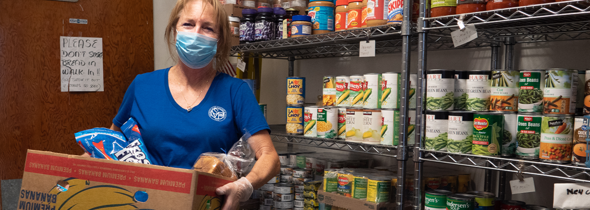 woman holding a box of food in a food pantry