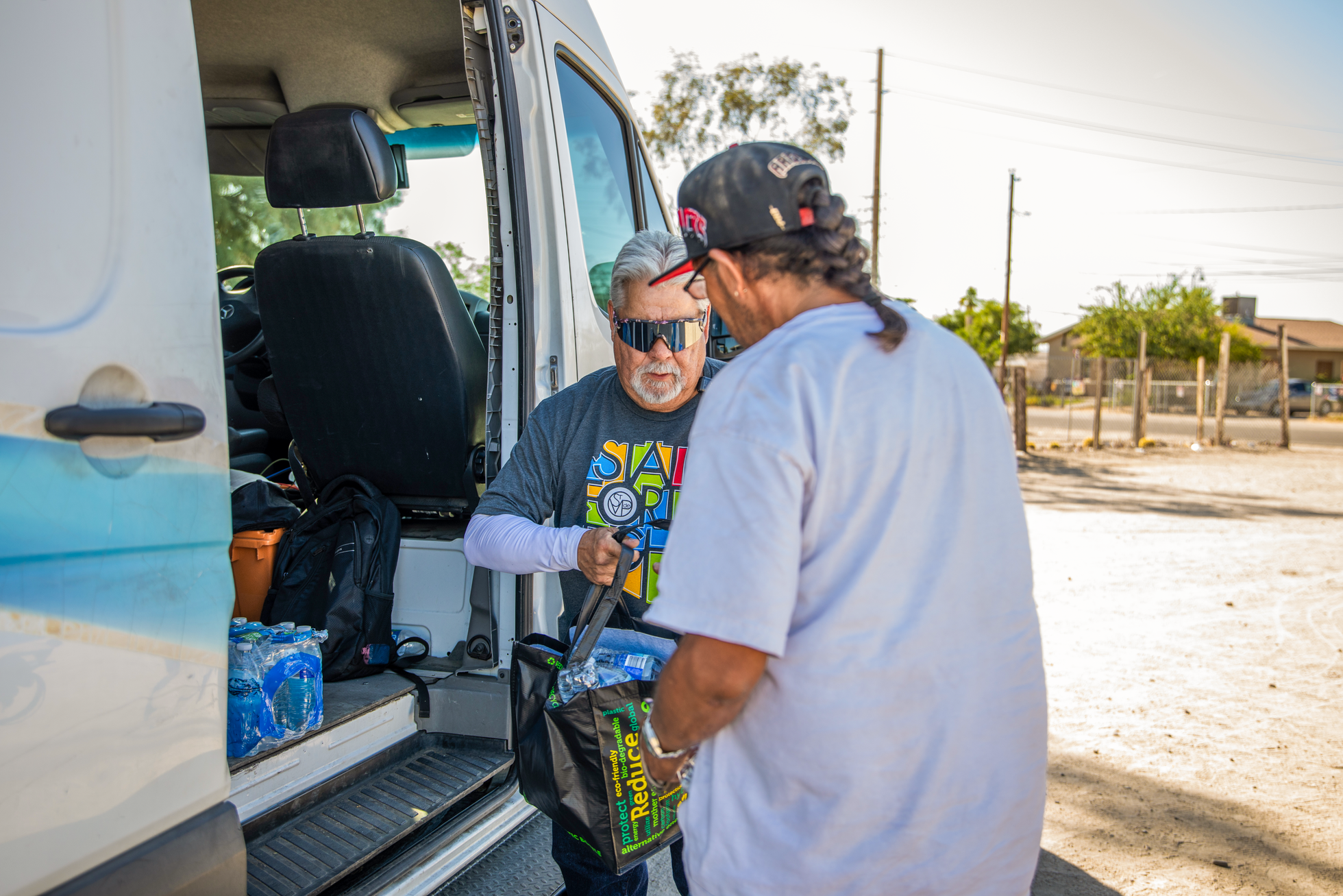 A man distributing water bottles to the community through the SVdP Water Truck.