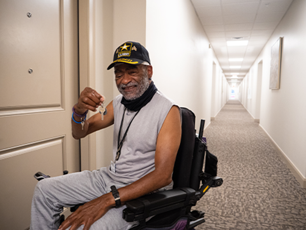 Man holding keys outside of a new apartment