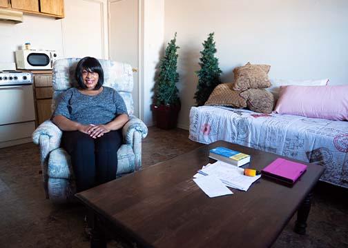 Woman smiling sitting on a chair in her apartment