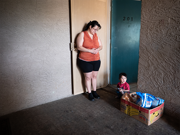 Woman and young boy outside of an apartment getting a food box