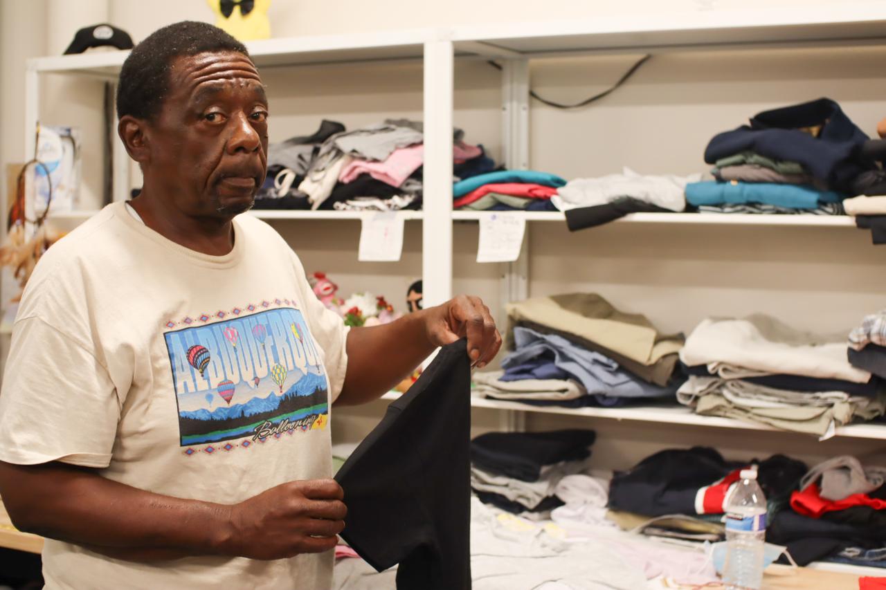 Man looking at the camera holding clothes