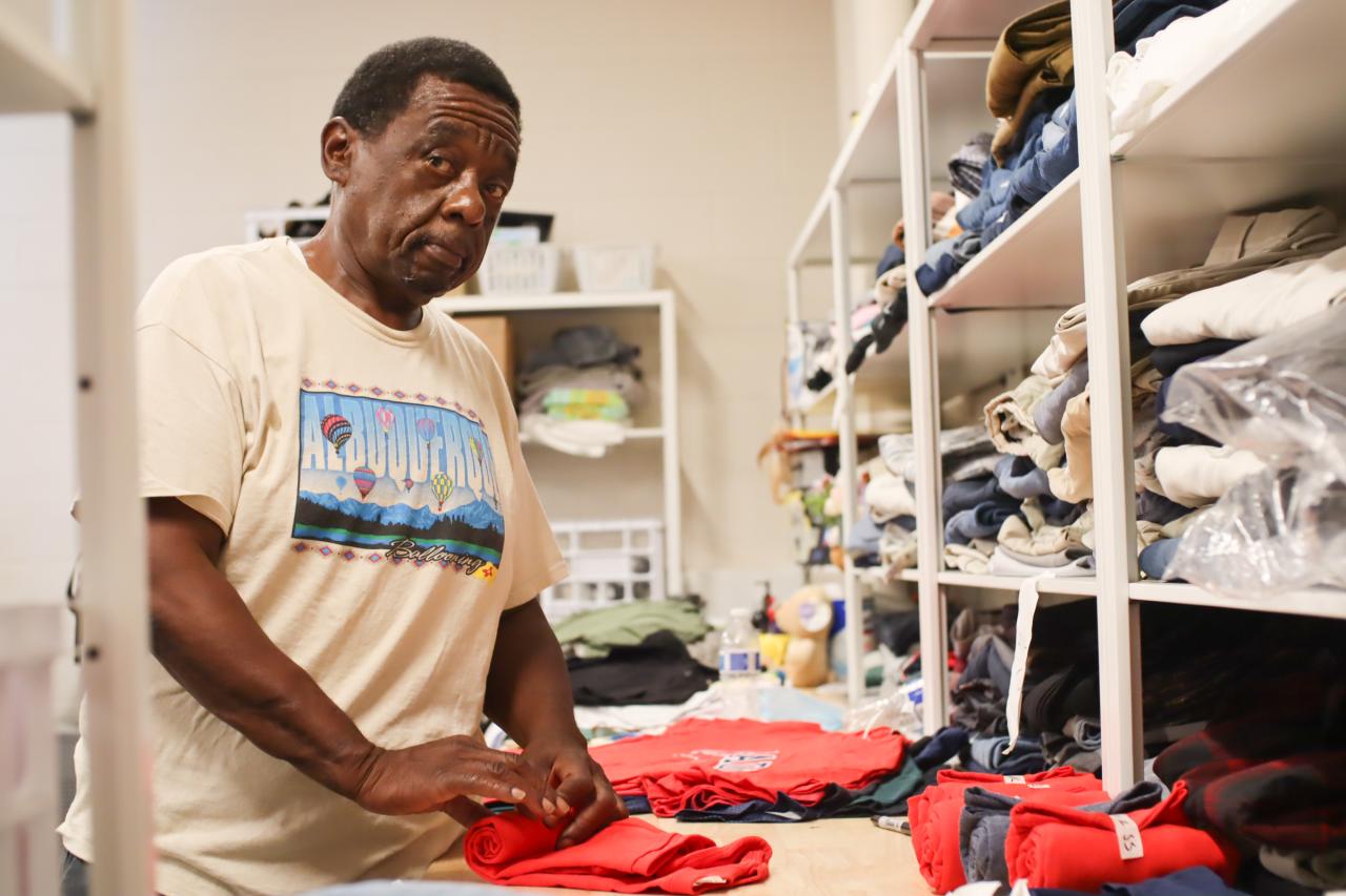 Man looking at the camera while folding clothes