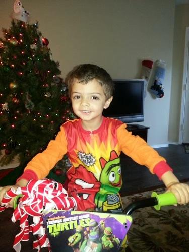 Young boy sitting on a bike Christmas morning