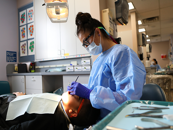 dentist cleaning the mouth of a young boy