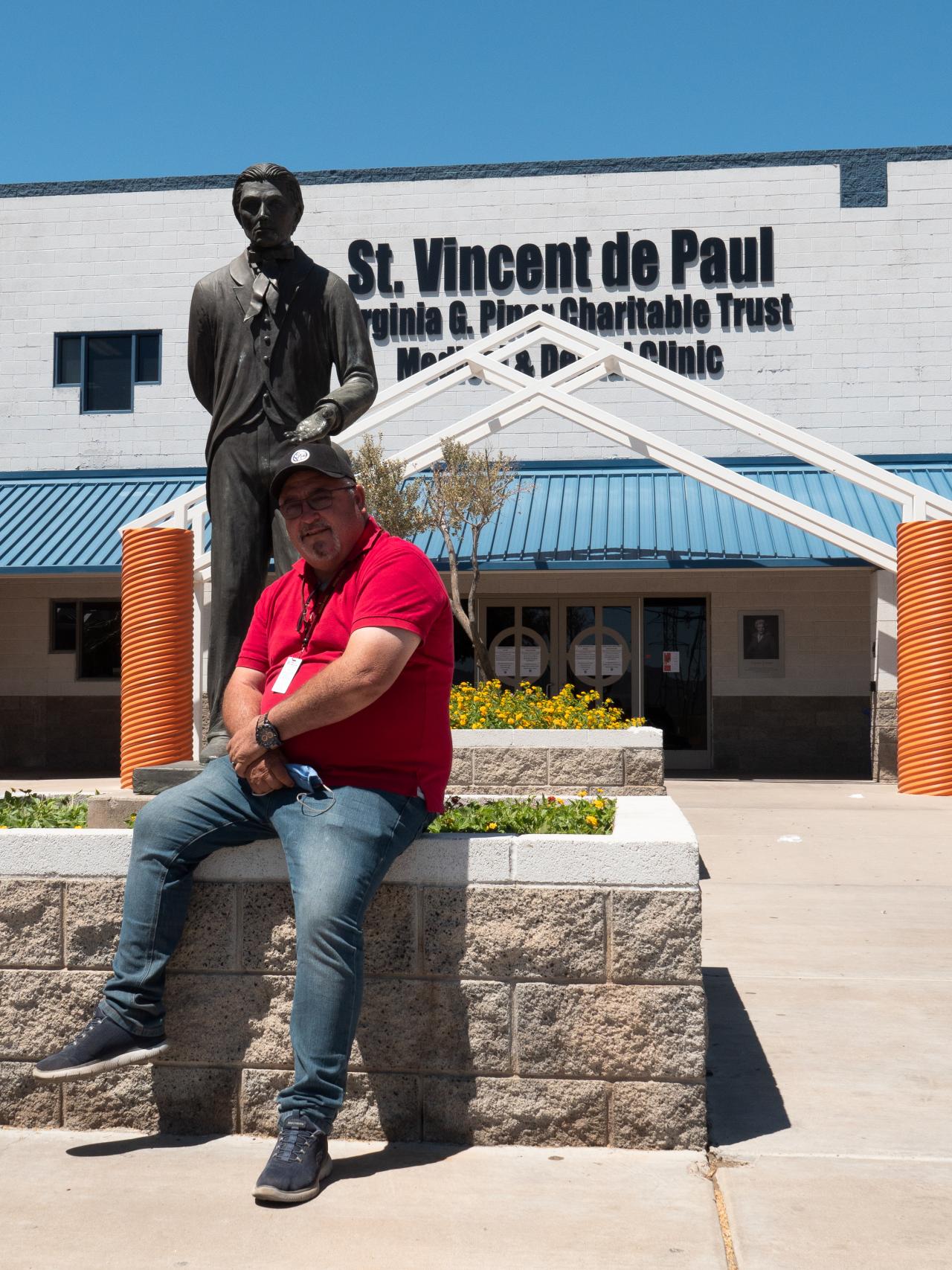 Man sitting at the foot of a statue