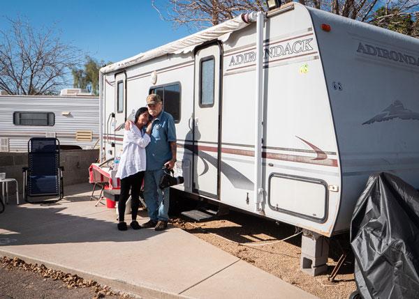Man and woman standing outside of an RV