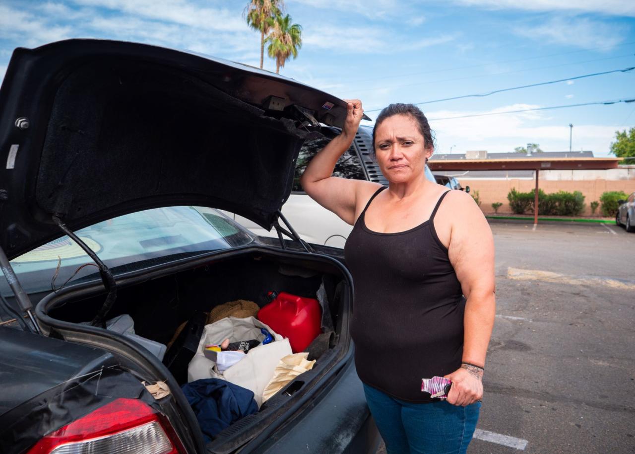 Woman standing next to a car with the trunk open