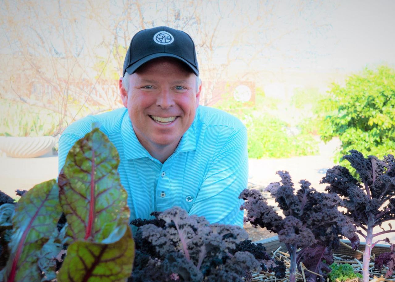 Man posing in front of vegetables