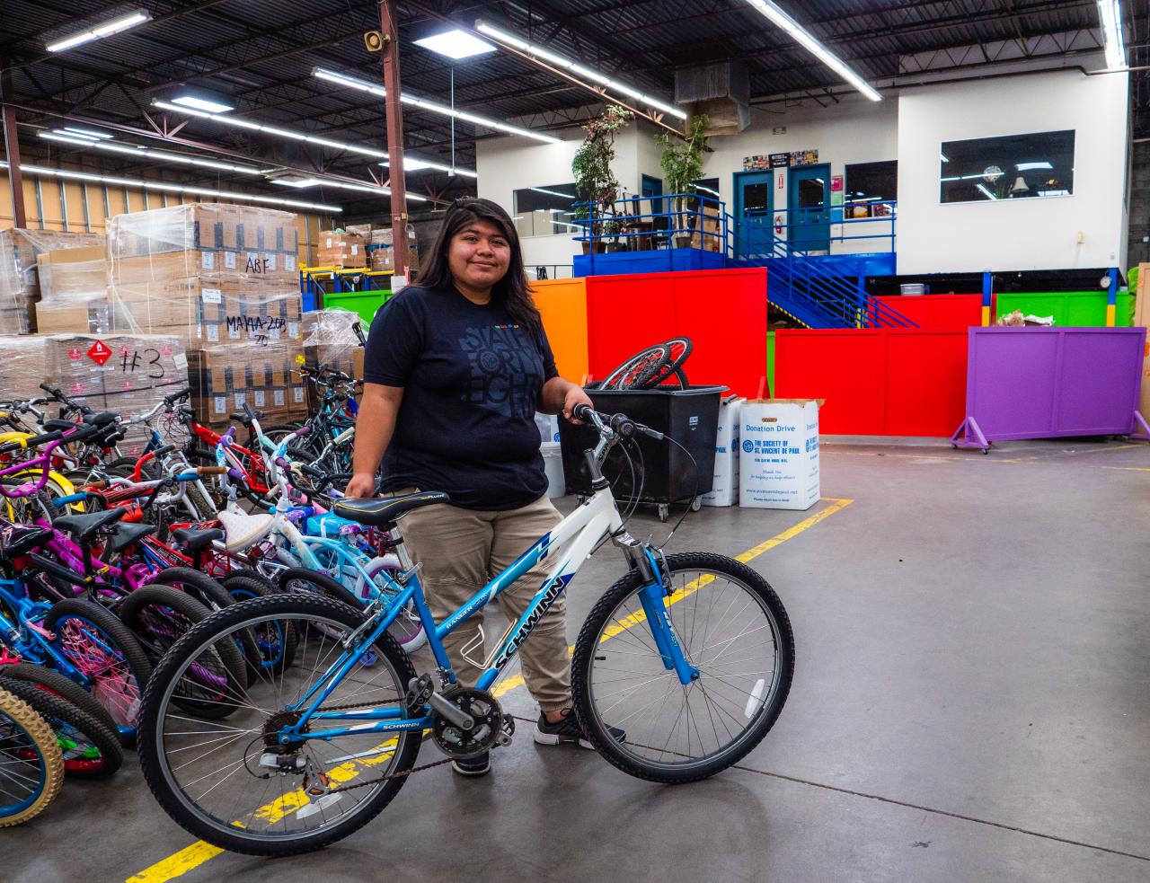 Odalys stands in bike shop with her new bike.