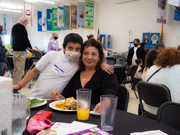 boy hugging his mom at a table