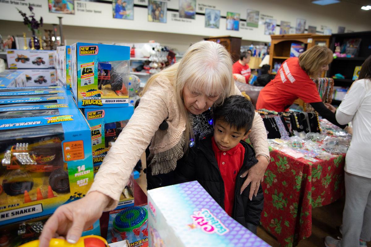 A volunteer helps a Palomino student pick out presents.