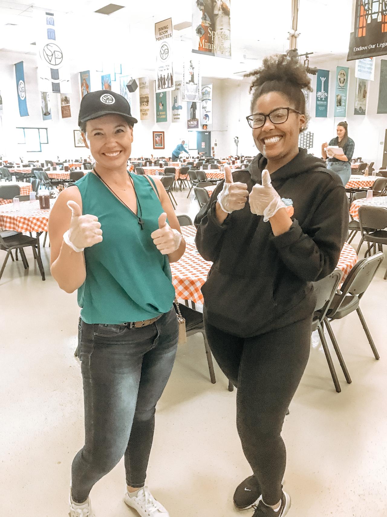 Women giving a thumbs up in a dining room